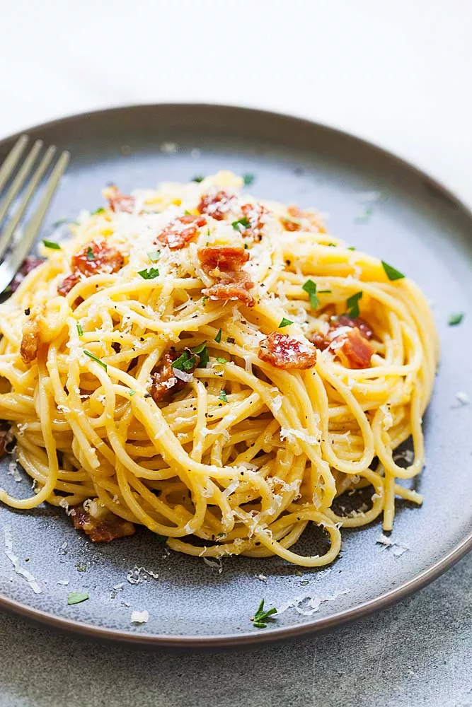 Spaghetti carbonara on a plate with a fork, ready to be served.