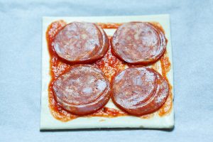 Puff pastry with bacon and tomato sauce.