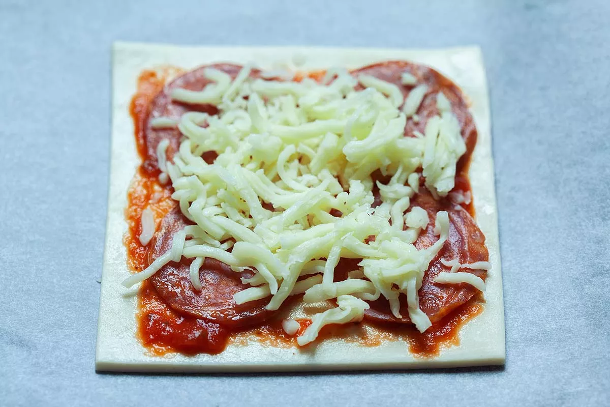 Puff pastry with bacon, tomato sauce and cheese.